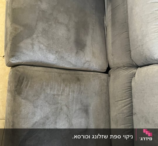 ספה אפורה עם כתמים כהים על המושב